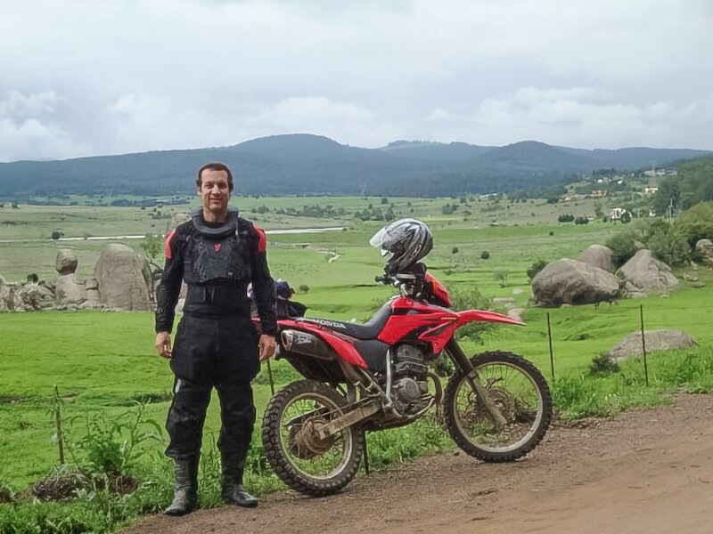 Baja Moose standing next to his Honda Tornado XR250 dual sport motorcycle